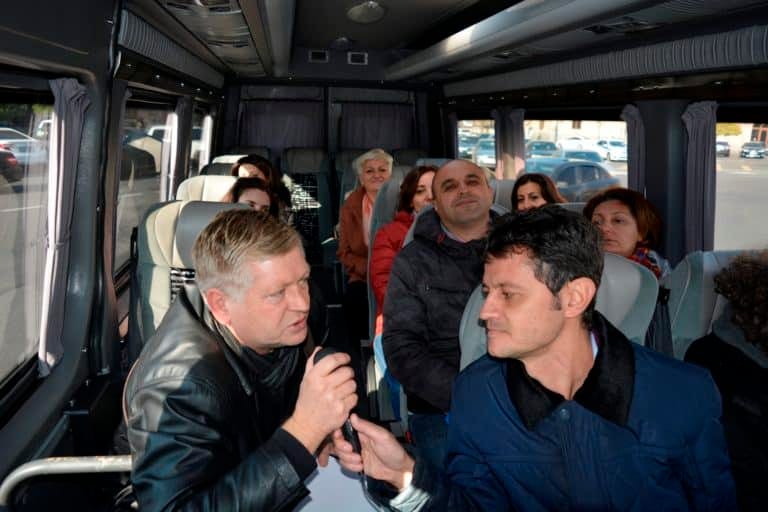 Guides practising commentary with a microphone on a moving coach
