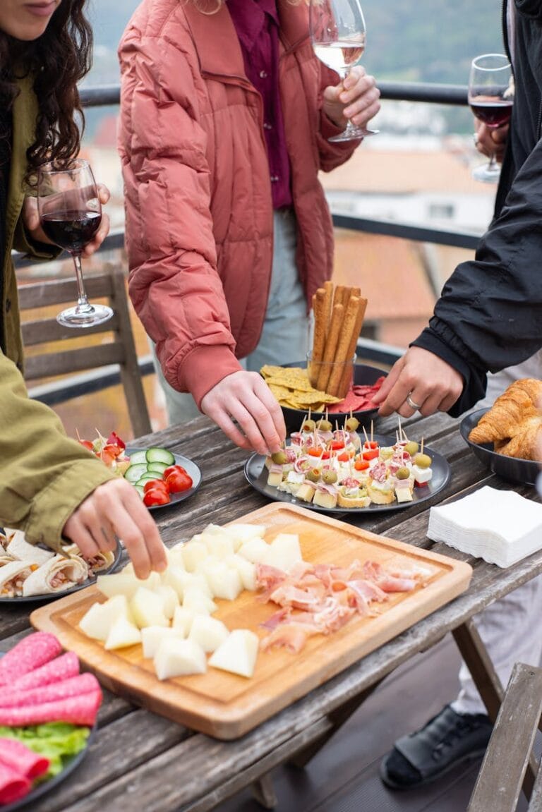 Group enjoying appetizers with wine outdoors in Portugal. Casual and inviting atmosphere.
