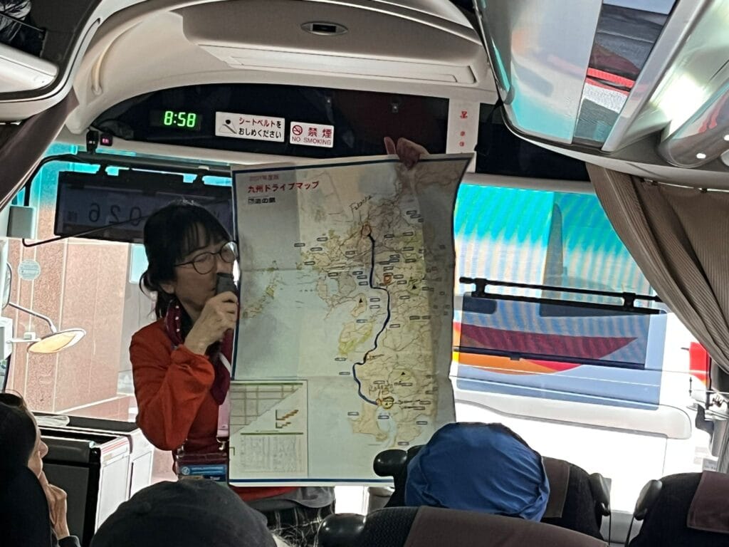 A tourist guide explaining the route on a map to her group on a coach in Japan