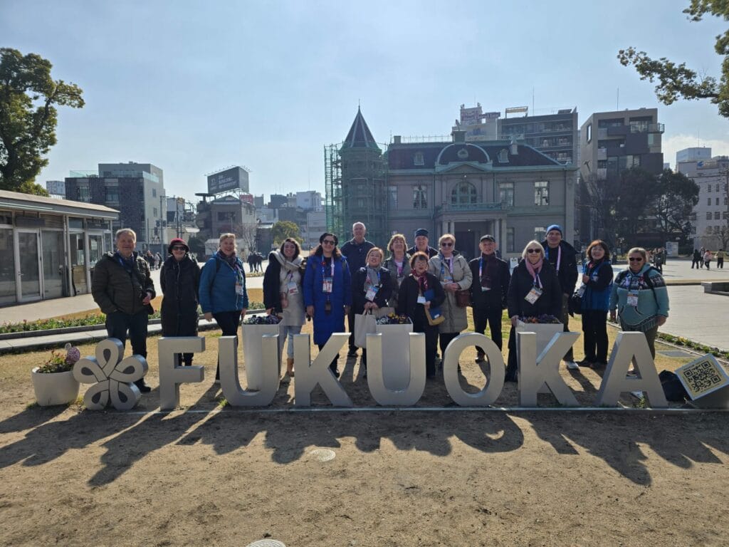 Tourist guides from many countries in front of the Fukuoka sign