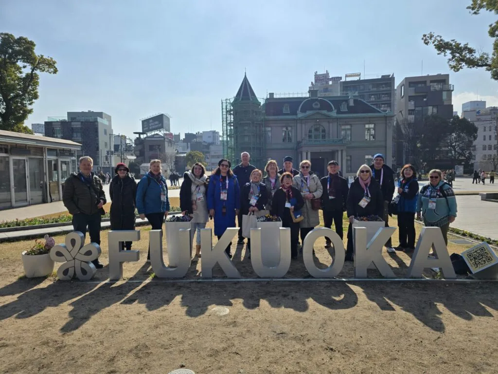 Tourist guides from many countries in front of the Fukuoka sign