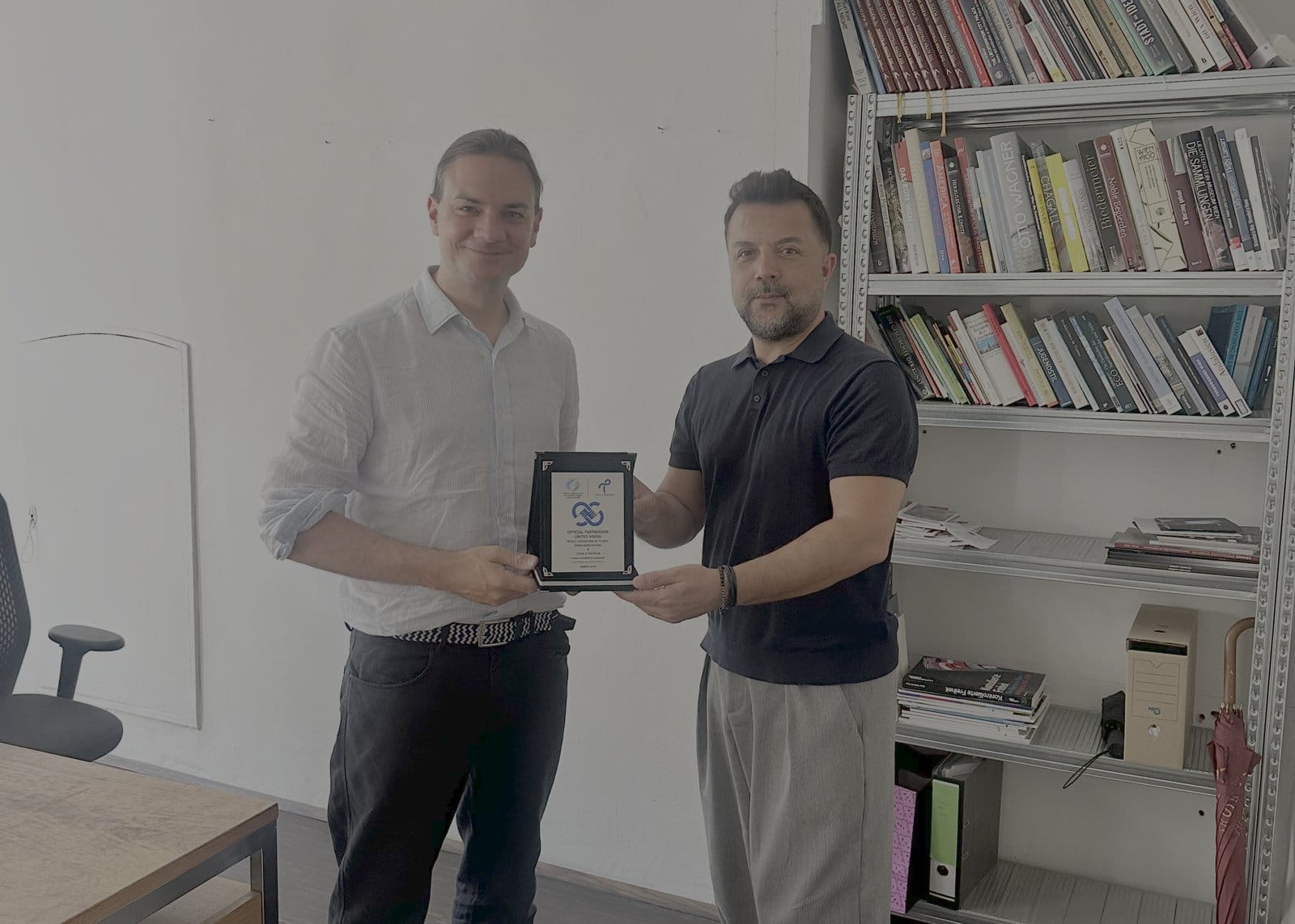 WFTGA President Sebastian Frankenberger and Local & Traveler Co-Founder Engin Özkaragöz exchanging the Official Partnership plaque in Vienna