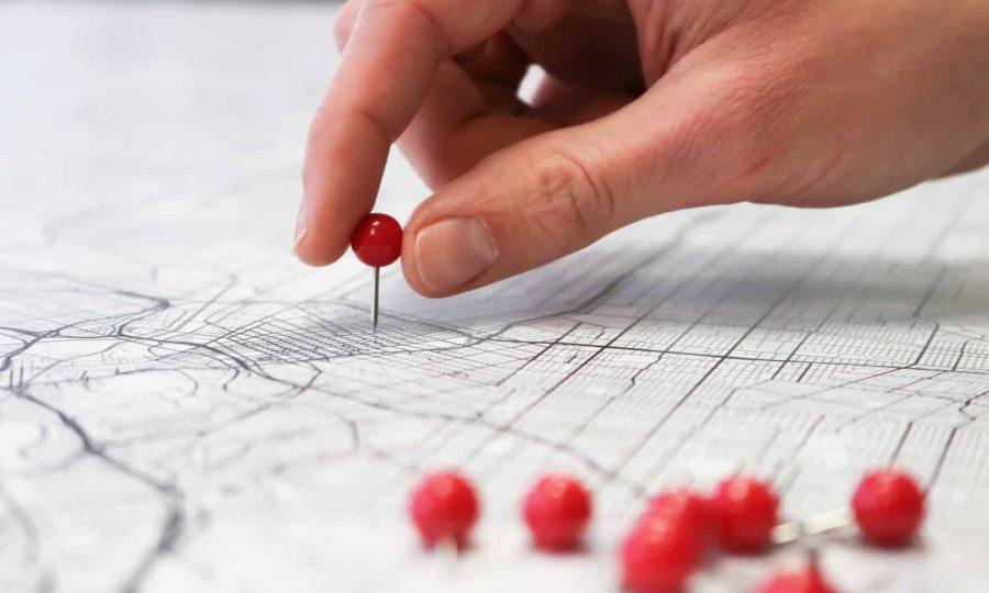 person holding red round medication pill
